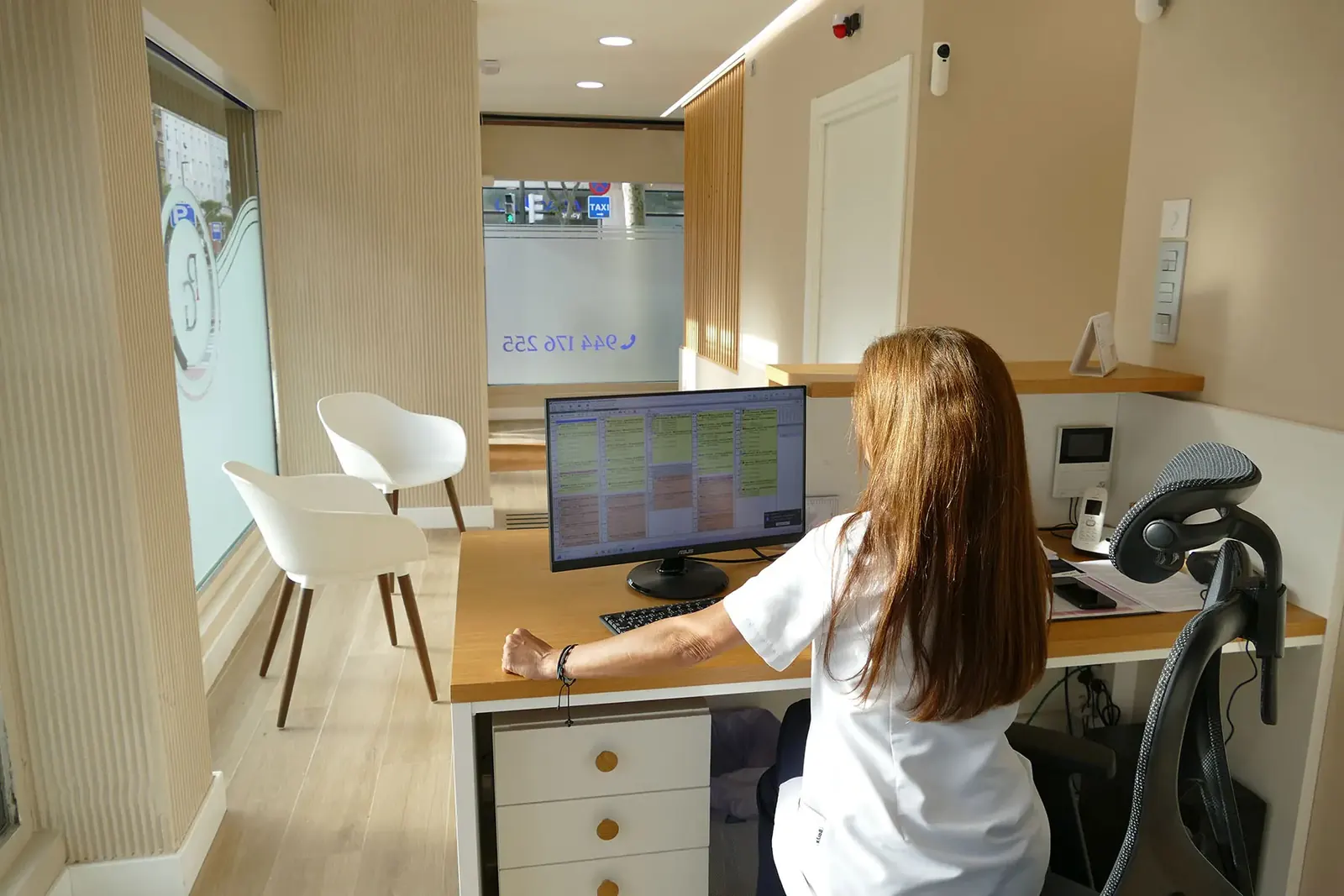 Atención al paciente en la Clínica Dental San Ignazio Auxiliar dental gestionando citas en la recepción de la Clínica Dental San Ignazio, Bilbao